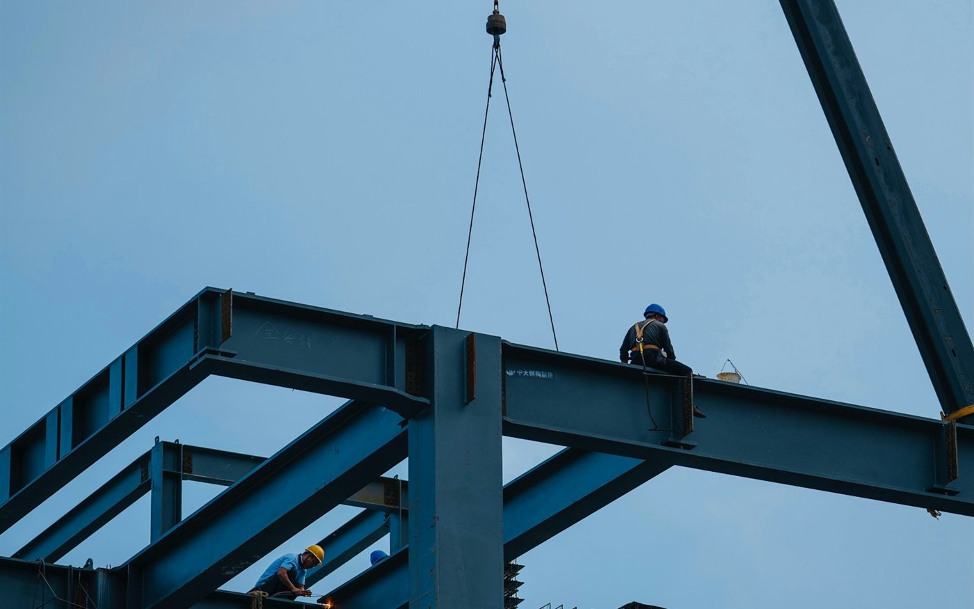 Ironworkers setting steel on a structural frame