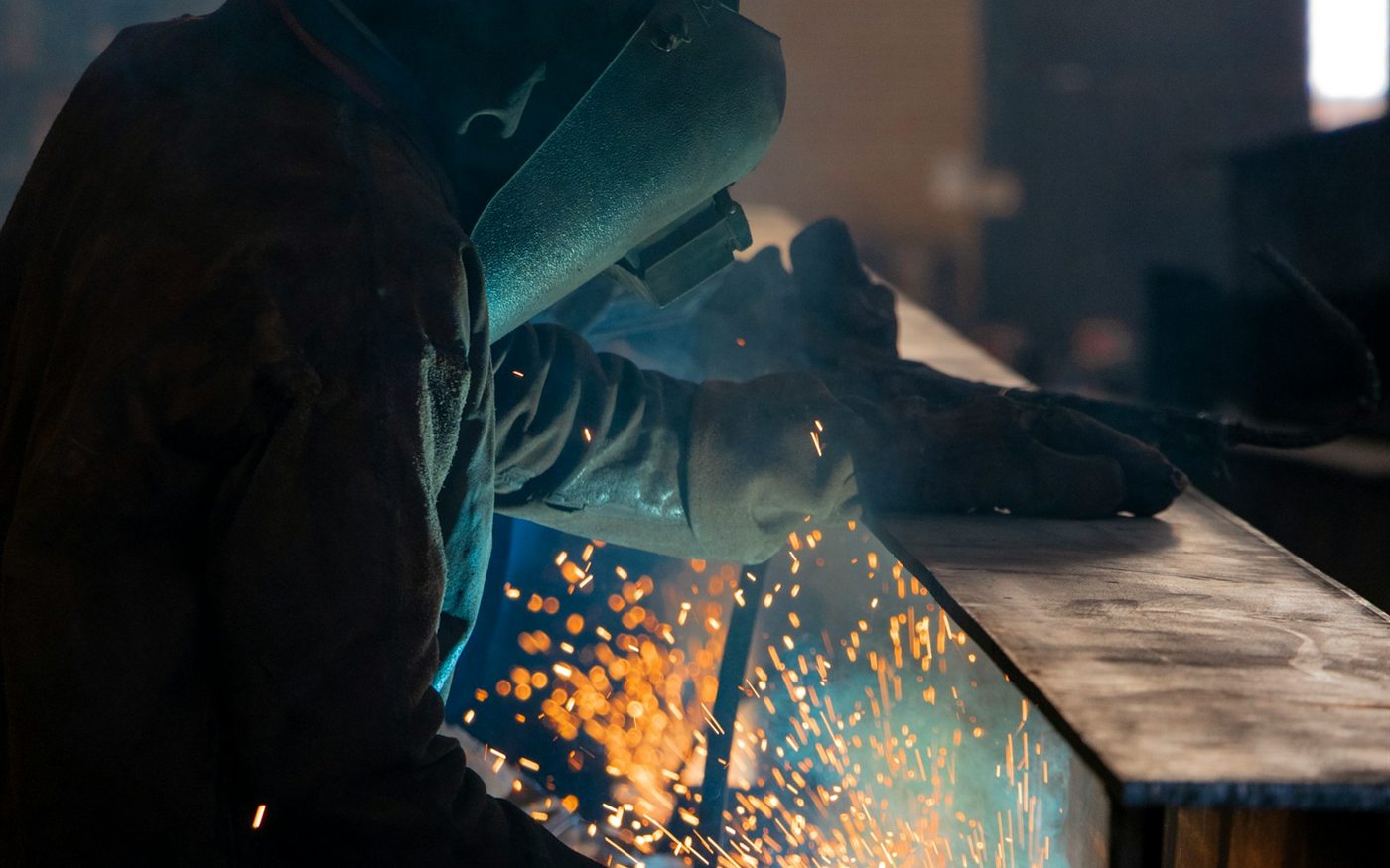 An AWS certified welder laying a bead on structural steel